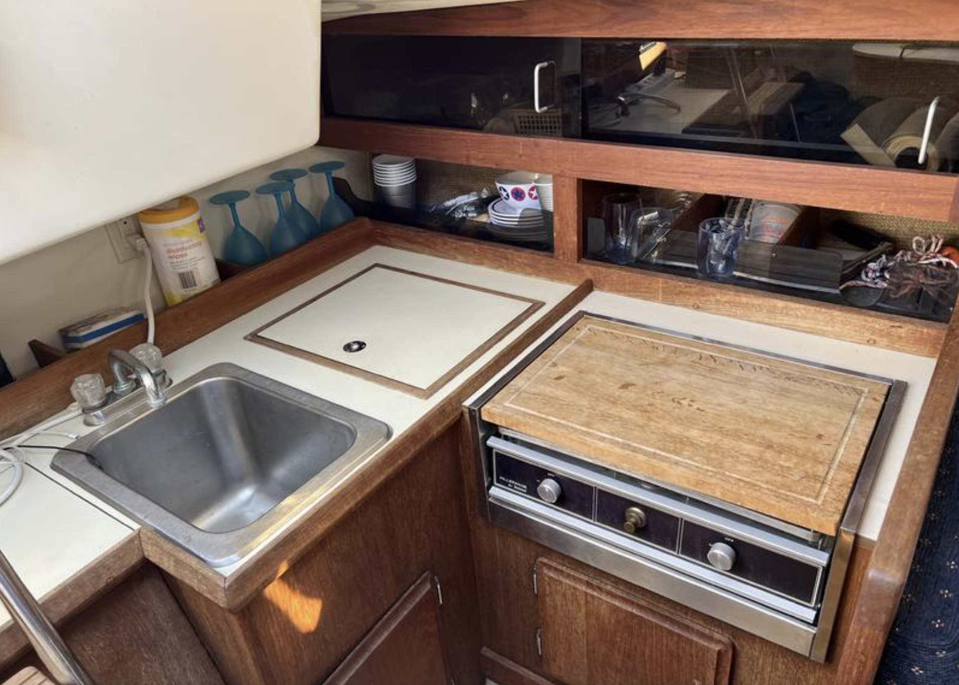 The galley is compact but functional. The icebox location in the aft port corner and single deep sink arrangement are typical of boats from this era—take out everything you need from the icebox before you start cooking. Photo courtesy of SailboatListings.com